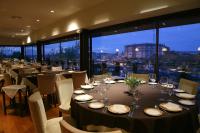 Un comedor con mesas y sillas con vista. en Santana Hotel & SPA, en Vila do Conde