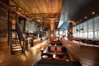 un restaurante con un bar con sofás y una escalera en Pan Pacific Melbourne, en Melbourne