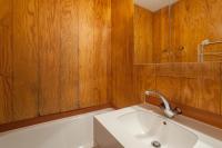 a bathroom with a white sink and wooden walls at Résidence Pierre &amp; Vacances Emeraude in Belle Plagne