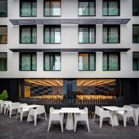 a row of tables and chairs in front of a building at Olivia Balmes Hotel in Barcelona