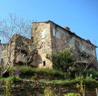 an old stone building on a hill with flowers at Appartement 2 chambres A Casa De Giovanni à Pietra-di-Verde en Haute-Corse in Pietra-di-Verde