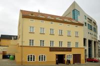 un edificio amarillo frente a un edificio alto en Pivovar Hotel Na Rychtě, en Ústí nad Labem