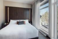 a bedroom with a bed and a large window at Entourage sur-le-Lac in Lac-Beauport