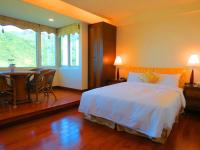 a bedroom with a bed and a table and a window at Formosa Arcadian Villa in Jiufen