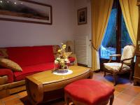 a living room with a red couch and a table at Hôtel-Logis La Coraline in Gannat