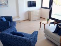a living room with two blue chairs and a couch at Apartments Vrutki in Opatija