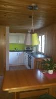 a kitchen with white cabinets and a wooden ceiling at Haus Silke in Silbertal