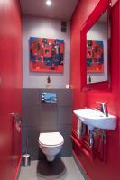 a red bathroom with a toilet and a sink at Veeve - Steps from the Eiffel Tower in Paris