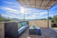 a patio with a couch and a tv and a table at Villa Sonnhaus in Marina