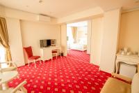 a hotel room with a red carpeted floor and a bedroom at MSR Port Hotel in Mangalia