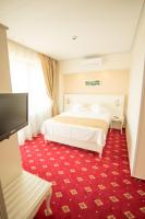 a hotel room with a bed and a flat screen tv at MSR Port Hotel in Mangalia