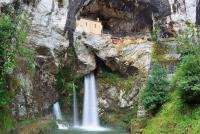 a waterfall in front of a building on a mountain at Casa Rural Priena in Covadonga