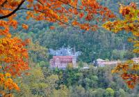 a building in the middle of a hill with trees at Casa Rural Priena in Covadonga