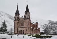 an old church in the snow with snow on it at Casa Rural Priena in Covadonga