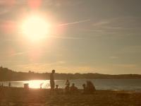 a group of people sitting on the beach at sunset at Toki Alai in Saint-Jean-de-Luz