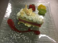 Ein Stück Kuchen mit Schlagsahne und Erdbeeren auf einem Glasteller in der Unterkunft Logis Hôtel - Restaurant Aux Bruyères in Orbey