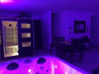 a purple room with a tub and a table at La Paillote Exotique Spa in Beaucaire