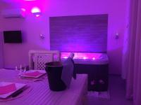 a purple room with a table with a bottle of wine at La Paillote Exotique Spa in Beaucaire
