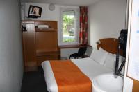 Una habitación de hotel con una cama, un escritorio y una ventana. en Hôtel Quick Palace Valence Nord, en Bourg-lès-Valence