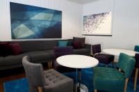 a living room with a couch and tables and chairs at Original Sokos Hotel Vaakuna Rovaniemi in Rovaniemi