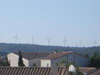 eine Gruppe von Windmühlen im Abstand hinter den Dächern in der Unterkunft Charmante chambre d&#39;hôte in Sigean