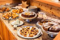 una mesa repleta de pasteles, dulces y tartas en Cavallino Lovely Hotel, en Andalo