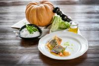 Una mesa con un plato de comida y una calabaza. en Hotel im Park, en Bad Radkersburg