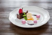 Un plato blanco con postres sobre una mesa de madera. en Hotel im Park, en Bad Radkersburg