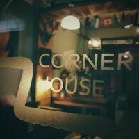 a window of a coffee house with the words corner house at 角舍背包客棧 -近火車站 in Hualien City
