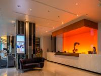 a woman sitting at a counter in a lobby at Chatrium Hotel Riverside Bangkok in Bangkok