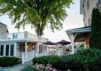 une maison avec une terrasse dotée de parasols et d'un arbre dans l'établissement Breakwater Inn, à Kennebunkport