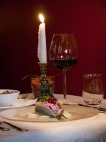 uma mesa com uma vela e um prato de comida e vinho em Hotel New Orly em Munique