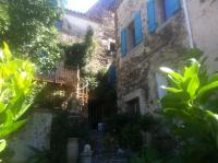 an old stone building with a staircase and a balcony at La belle endormie in Cabrerolles