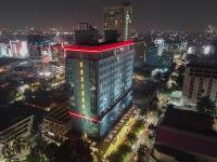 Un edificio iluminado en una ciudad por la noche. en Aria Centra Surabaya, en Surabaya