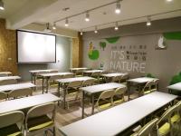 an empty classroom with tables and chairs and a screen at Green Hotel - Fengjia in Taichung