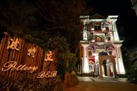 a building with a clock on it at night at Pottery B&amp;B in Jiaoxi