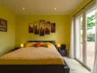 a bedroom with a bed with yellow walls and a window at Luxury holiday home with private pool in Rodilhan