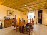 a dining room with a wooden table and chairs at Luxury holiday home with private pool in Rodilhan