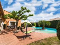 a backyard with a pool with a swing and an umbrella at Luxury holiday home with private pool in Rodilhan