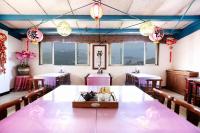 a dining room with tables and chairs and lights at Yuan-Yee Homestay in Jiufen