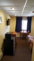 a room with a bed and a desk and a table at Atlantic Motel in Point Pleasant Beach