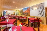 Un restaurante con mesas y sillas rojas y un cuadro en la pared. en Hotel Parras Arnedillo, en Arnedillo