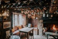a room with a table and a fireplace at The Falkland Arms in Chipping Norton