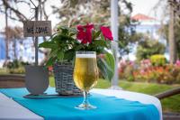 Un vaso de cerveza sobre una mesa con una flor. en Hotel Talisman, en Ponta Delgada