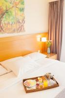a tray with breakfast foods on a bed at Athinais Hotel in Athens