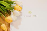 a white vase with yellow flowers on a table at Athinais Hotel in Athens