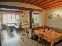Una sala de estar con mesas y un comedor. en Gasthaus zum Ochsen, en Neuhaus
