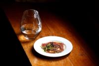 een bord eten en een glas water op een tafel bij Hotel Molí de l'Escala in L'Escala