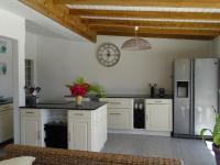 a kitchen with white cabinets and a stainless steel refrigerator at Villa Acajou in Saint-François