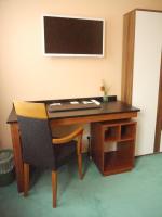 a desk with a chair and a monitor on a wall at Apart Pension Plaue in Brandenburg an der Havel